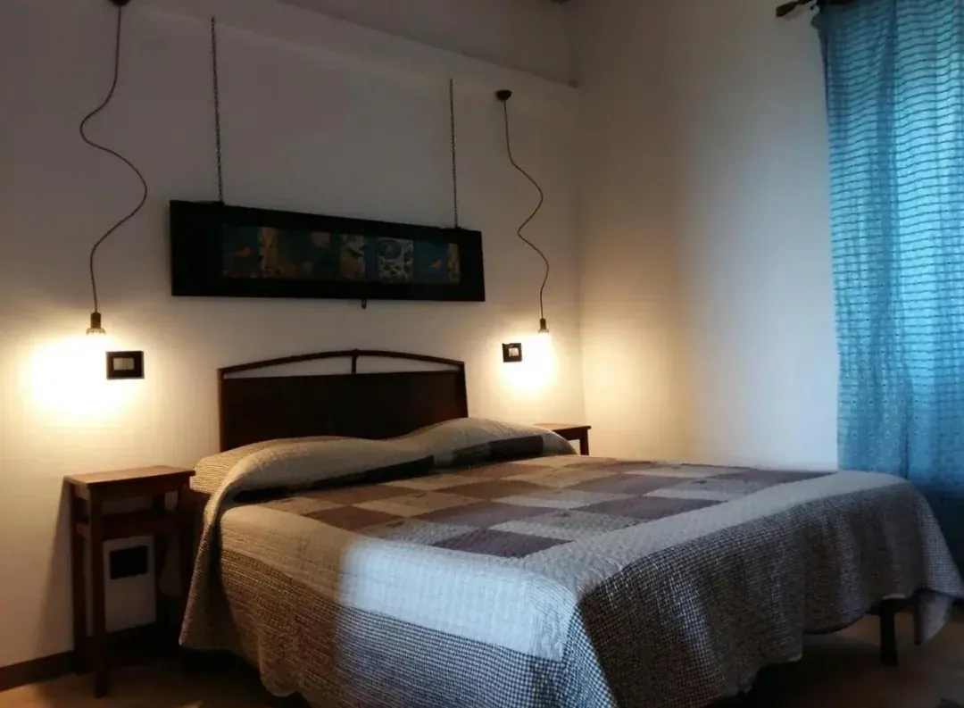 La camera Noce, con letto matrimoniale e testiera in legno
